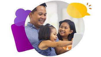 smiling man with two young girls looking at a device
